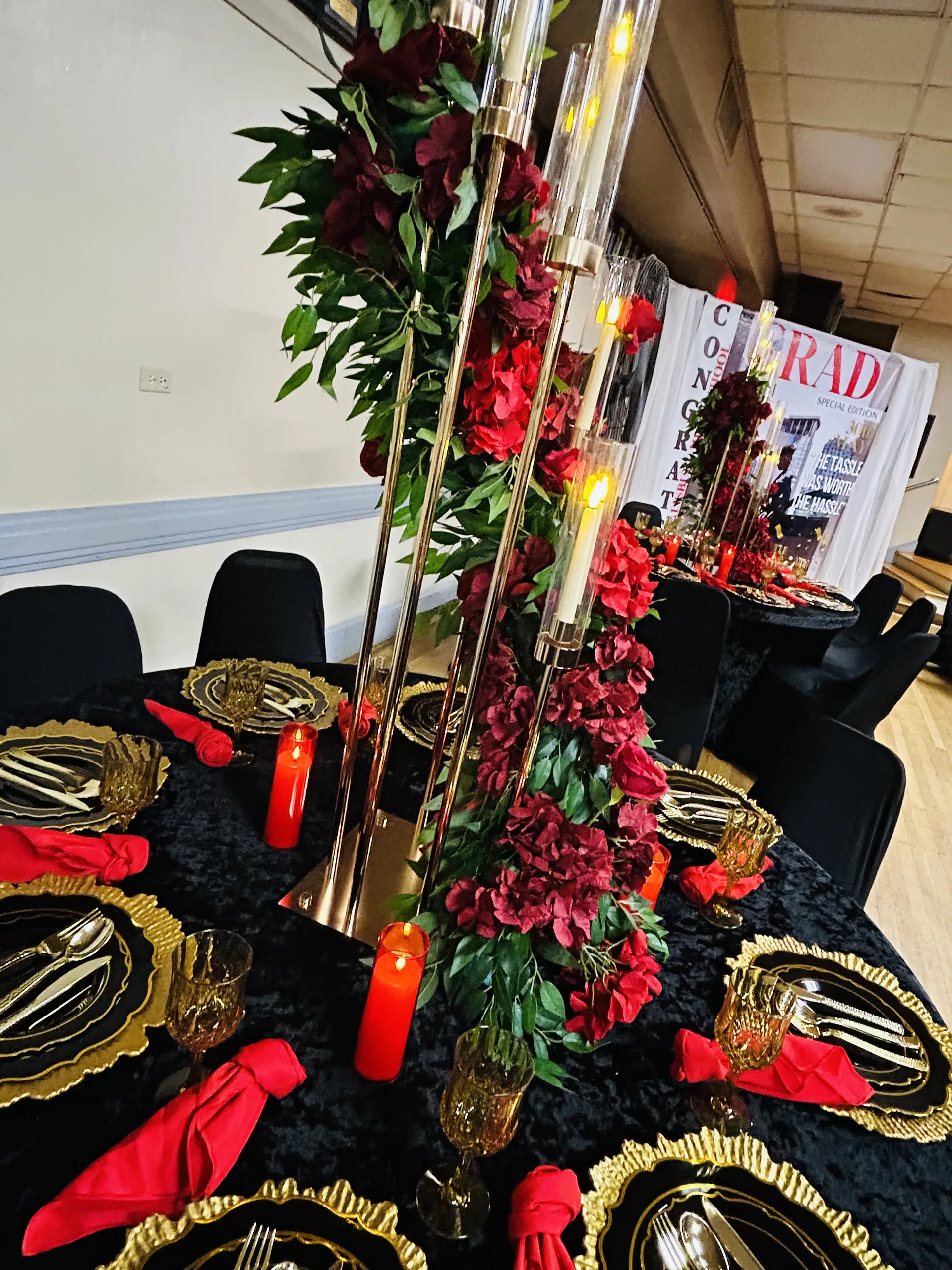 Red floral garland with black and gold graduation tablescape