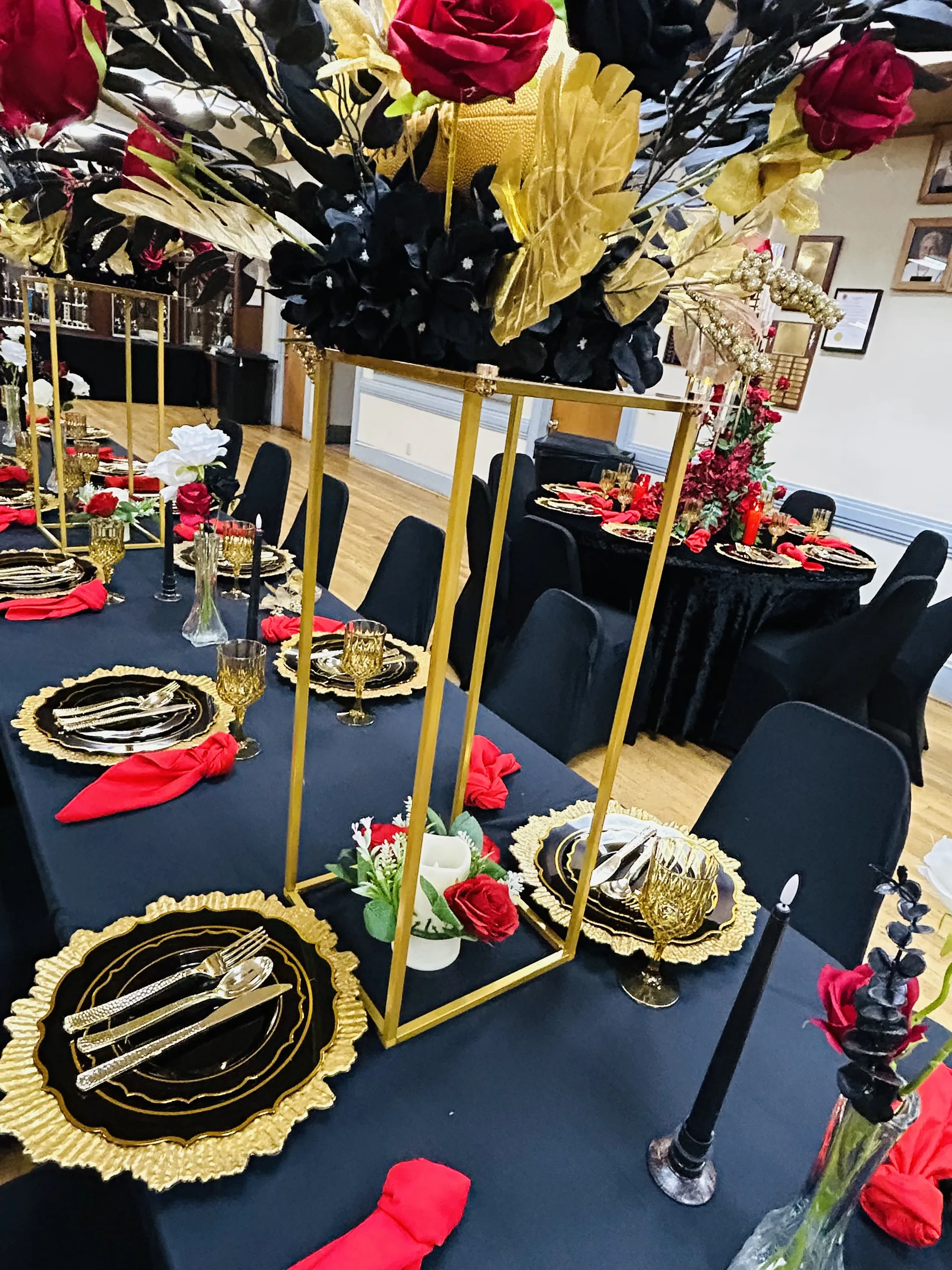 Black and gold table setting with tall floral centerpiece