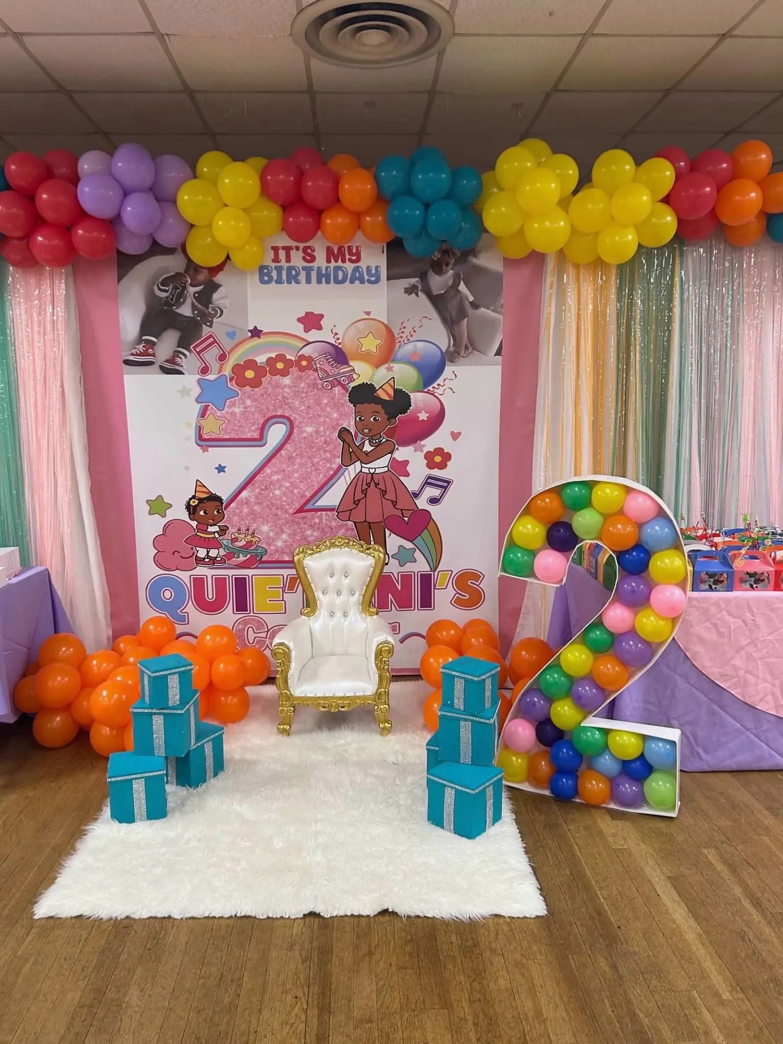 Second birthday photo area with balloon-filled number two and custom backdrop