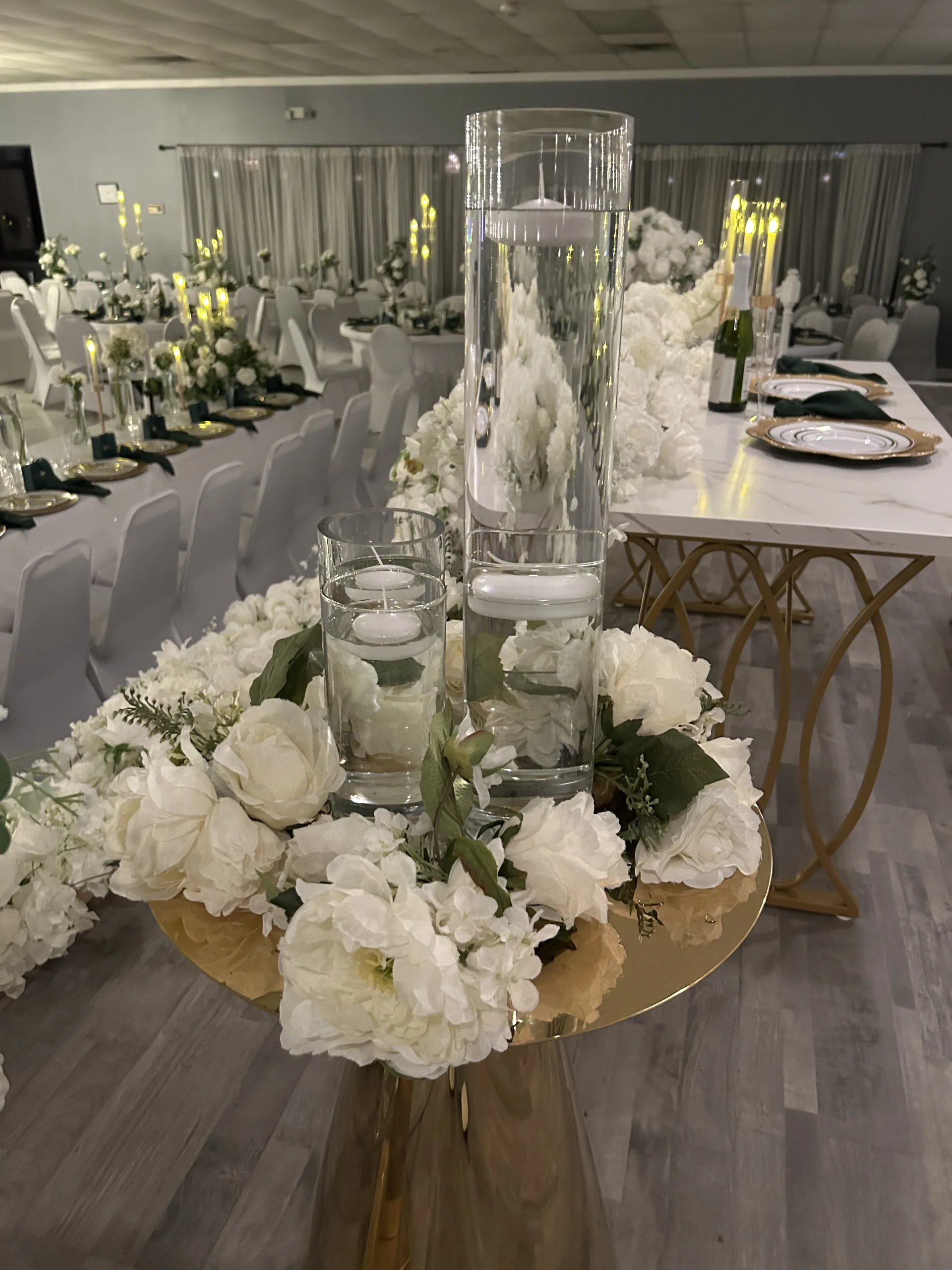 White floral aisle arrangement with glass candle holders