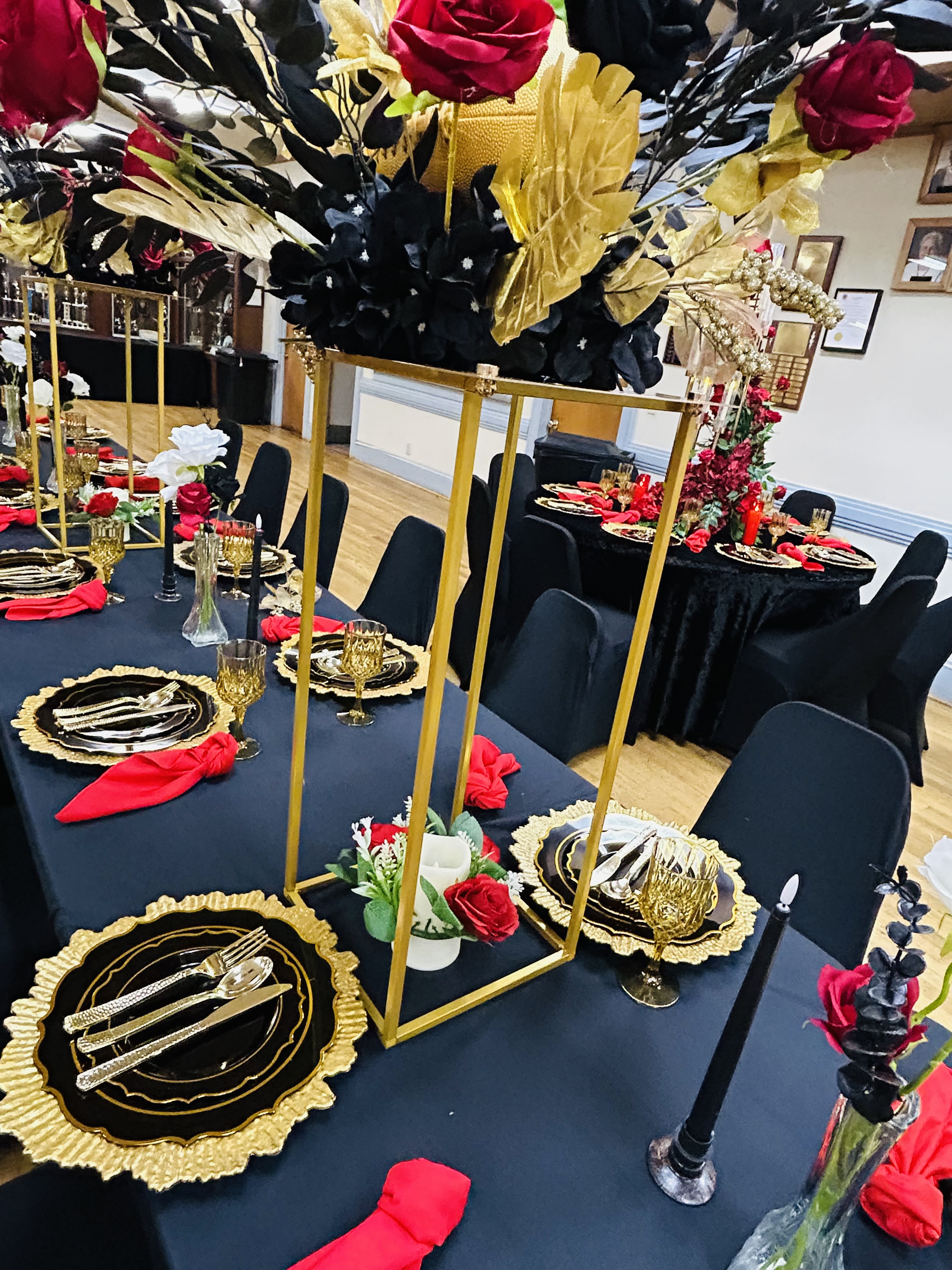 Black and gold table setting with tall floral centerpiece